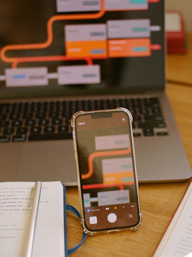 A follow-up pipeline shown on a laptop and phone on a warm desk.